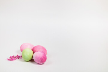 Multi-colored eggs with twigs, on a white background with a place for text.