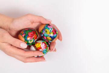Easter. Khokhloma eggs in the hands of a girl, on a light background.