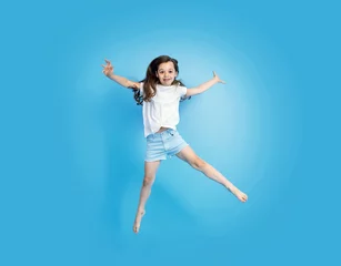 Foto op Canvas Portrait of a cute, jumping little girl © konradbak
