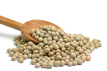 Getrocknete Erbsen auf einem Holzlöffel vor weißem Hintergrund