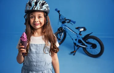 Foto op Aluminium Closeup portrait of a cute little girl eating an ice cream © konradbak