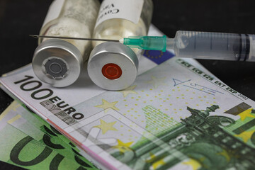 Pandemic Concept and money ( euro) to Vaccinate. Vaccine Bottle with Syringe for Covid-19	