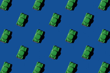 Toy retro green car in seamless pattern on blue background. 