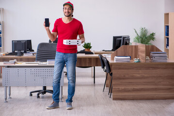 Young male courier delivering pizza to the office