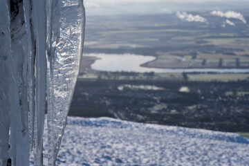 View of a meandering river Forth in Forth Valley from a snow covered hill in Scotland with an...