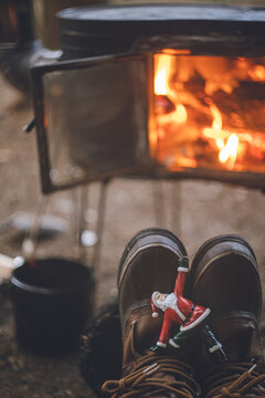 ヨガをするサンタクロースの置物と冬のキャンプ。薪ストーブの暖かい火。