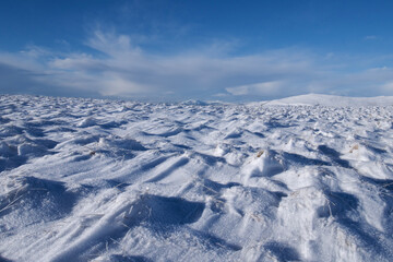 Fototapeta na wymiar snow waves pattern on a hill