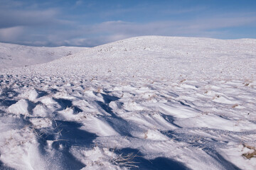 Fototapeta na wymiar View of snow covered hilly landscape in Scotland