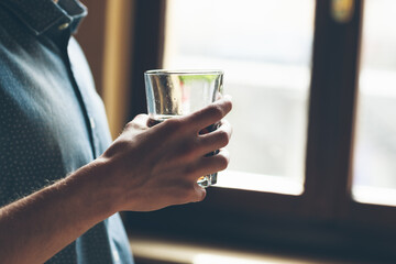 Male hand holding a glass