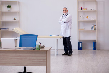 Old male doctor working in the clinic