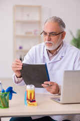 Fototapeta premium Old male dentist working in the clinic