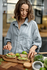 Beautiful woman with healthy green food in kitchen