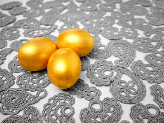 Golden Easter eggs on vintage lace background. The concept of a bright Easter