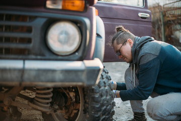 A man repairs a car, puts wheels, changes seasonal tires