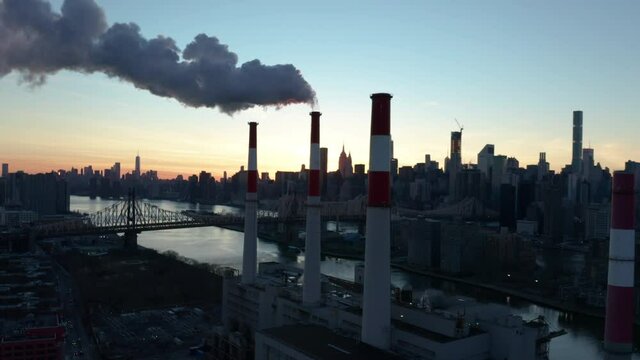 sunset flying counter clockwise around smoking LIC power plant