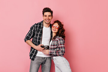 Blissful couple hugs in valentine's day. Studio shot of brunette man embracing girlfriend on pink background.