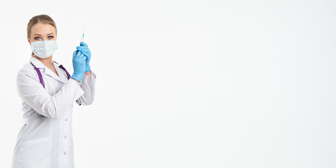 A young nurse in a mask and white coat holds a syringe with a needle for injections, flu shots, covid. The concept of vaccination and protection against influenza, from a pandemic. copy space. banner