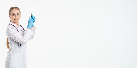 A young nurse in a mask and white coat holds a syringe with a needle for injections, flu shots, covid. The concept of vaccination and protection against influenza, from a pandemic. copy space. banner