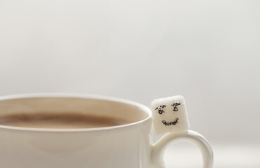 White sugar cube on cup of coffee. Smile. Concept.