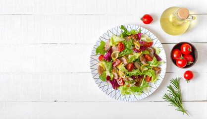 Diet salad with magre duck breast, fresh herbs, vegetables and mustard sauce on a light wood background. Top view, flat lay