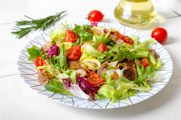 Diet salad with magre duck breast, fresh herbs, vegetables and mustard sauce on a light wood background