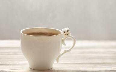 White sugar cube on cup of coffee. Smile. Concept.