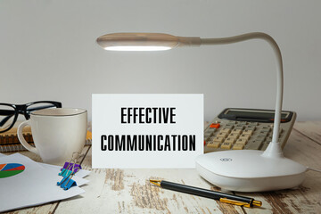 Desktop with a lamp that illuminates the inscription Effective Communication