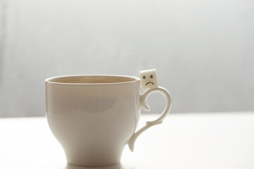 White sugar cube on cup of coffee. Smile. Concept.