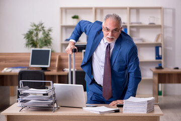 Old businessman employee after accident working in the office