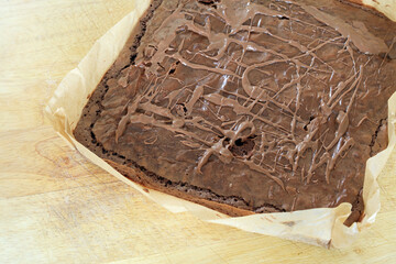 A Freshly Baked Homemade Chocolate Brownie Slab Cooling On A Wooden Board