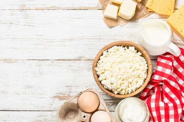 Dairy product at white wooden table. Curd, milk, yogurt, cheese and eggs. Organic farmer food. Top view with copy space.