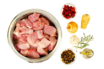 Chunks of fresh raw meat in metal bowl on white background. Studio Photo