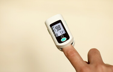 Pulse oximeter on finger showing oxygen saturation and heart rate. Oxymeter.