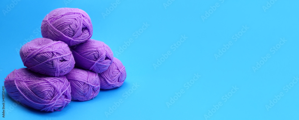 Poster skeins of woolen threads in a pyramid on a blue background. horizontal banner. copy space for text