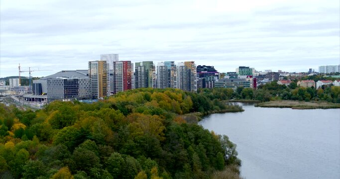 Flying over a lake in central Solna with apartments and sports arena in the background, Sweden
