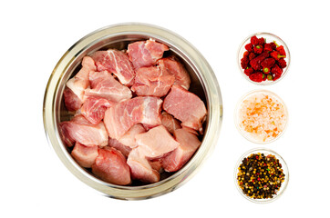Chunks of fresh raw meat in metal bowl on white background. Studio Photo