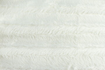 Fototapeta na wymiar White fluffy fur furry plaid for bed, bedding texture, stripes pattern, wrinkled woven light material 