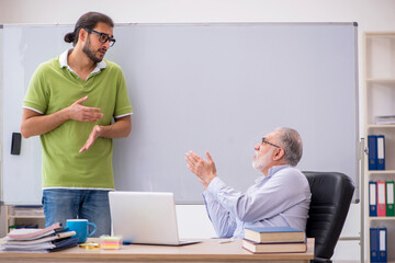 Obraz premium Old male teacher and young male student in the classroom