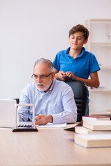 Obraz premium Old male teacher and schoolboy in the classroom