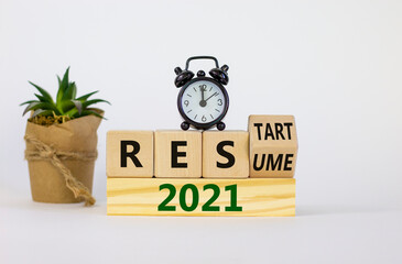 2021 resume and restart symbol. Turned a cube and changed words '2021 resume' to '2021 restart'. Alarm clock. Beautiful white background. Business and 2021 resume - restart concept. Copy space.