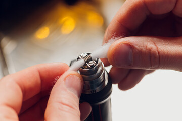 Specialist replaces spring for smoking vape.Professional maintaining electronic cigarette in...