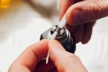 Specialist replaces spring for smoking vape.Professional maintaining electronic cigarette in...