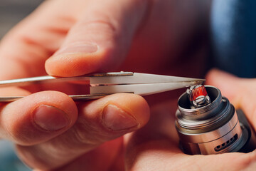 Specialist replaces spring for smoking vape.Professional maintaining electronic cigarette in...