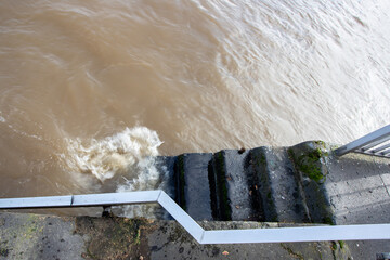 stony stairs that lead into water because of flood, splashing water