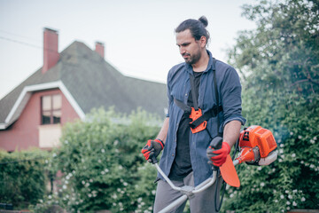 A man mows the grass with a hand mower in the garden