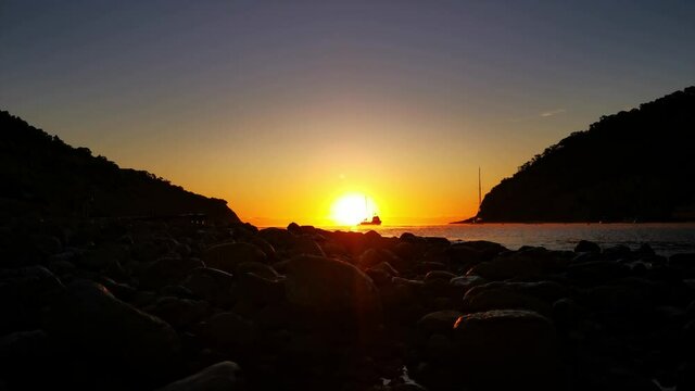 Idyllic sunrise in a bay of isle Ibiza with silhouette of a ship