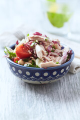 Salad with tuna, tomatoes and cucumber. Wooden background. Close up.