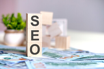 dollars banknote with calculator and word SEO. Banknotes and wooden cubes with letters, business...