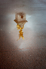 Reflecion in a puddle of the gold Victory Angel of the Vitoria Memorial, London, UK