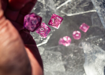 Hand throwing pink dice